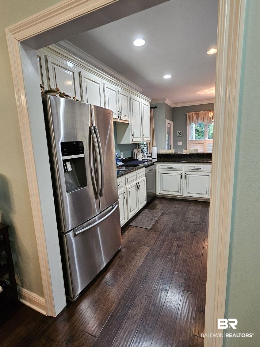 41416 Davis Duck Road Bay Minette, AL 36507 - Photo 27 of 72 Kitchen with stainless steel fridge, crown molding, dark hardwood / wood-style flooring, and white cabinets