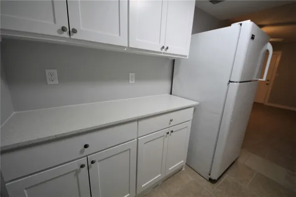 a kitchen with cabinets and a refrigerator
