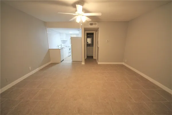 a view of a big room with wooden floor and chandelier fan
