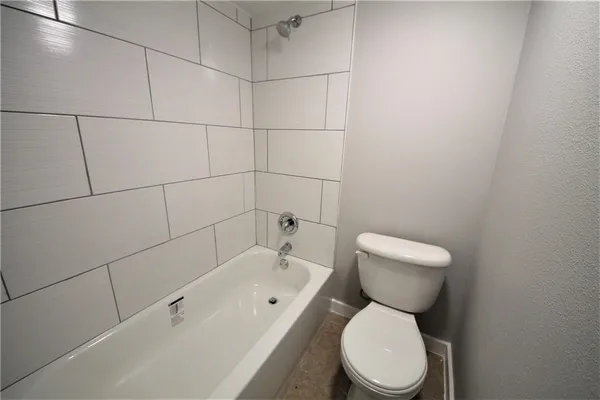 a white toilet sitting next to a bath tub