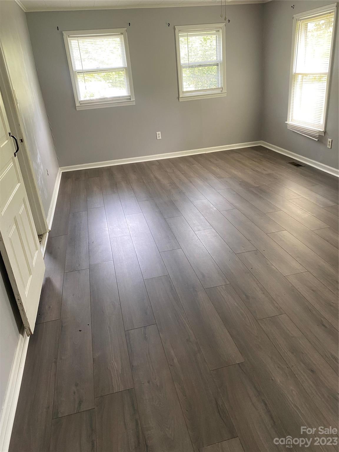 17183 Pond Road Locust, NC 28097 - Photo 9 of 14 an empty room with wooden floor and windows