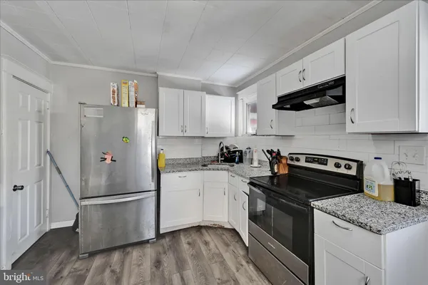 a kitchen with stainless steel appliances granite countertop a refrigerator sink and stove