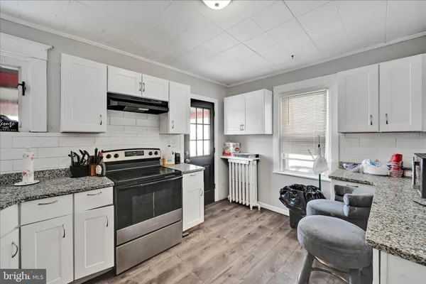 a kitchen with sink a stove and cabinets