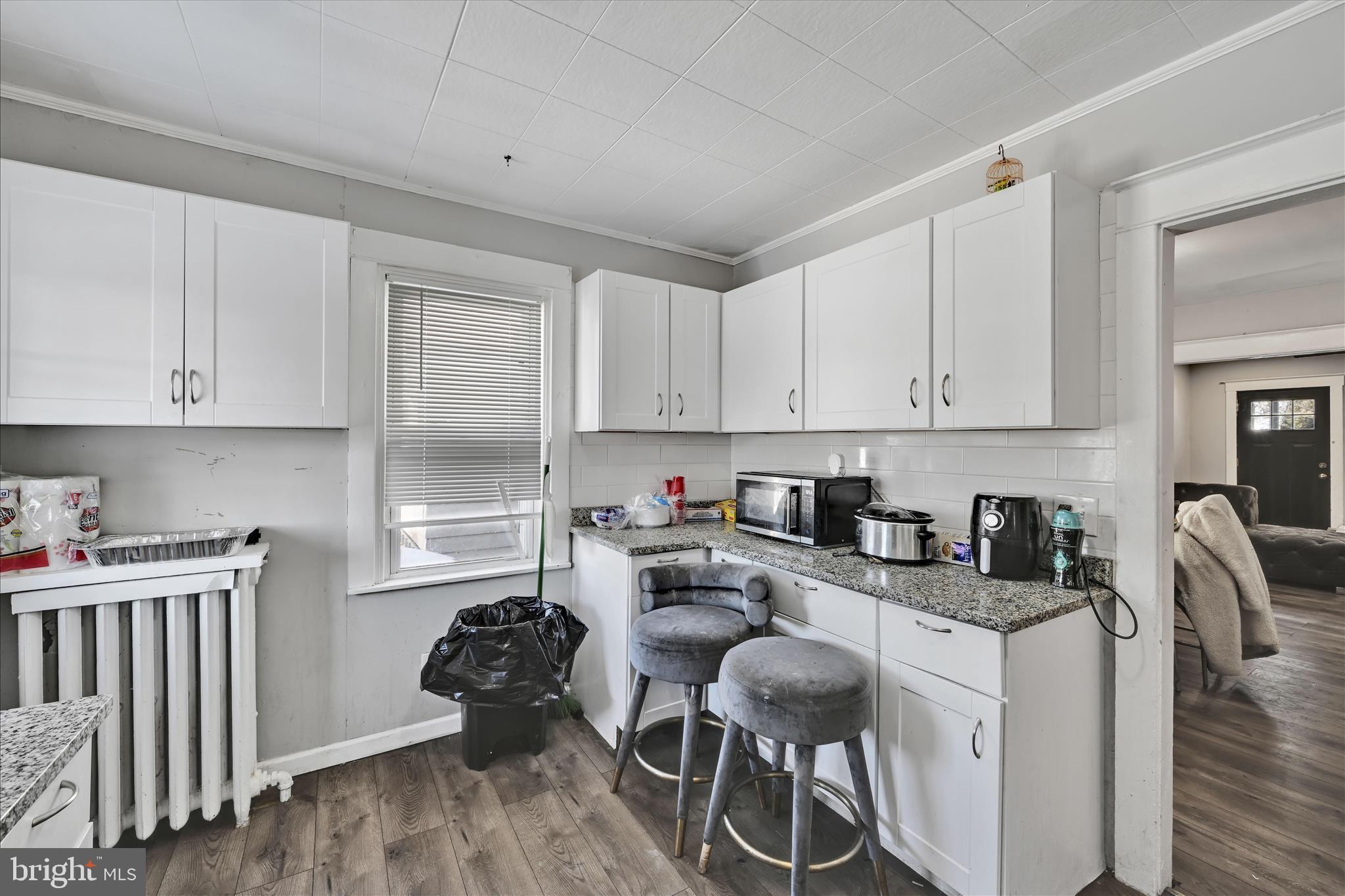 204 East Avon Road Brookhaven, PA 19015 - Photo 13 of 26 a kitchen with stainless steel appliances granite countertop a stove top oven a sink dishwasher and white cabinets with wooden floor