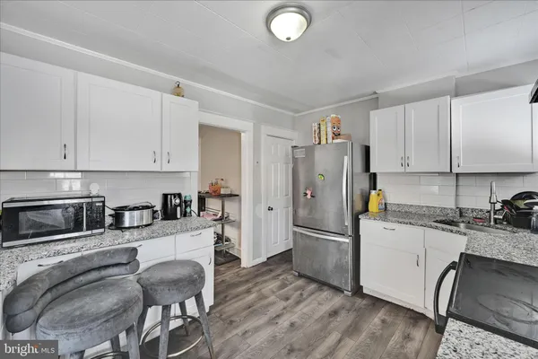 a kitchen with granite countertop a refrigerator stove and sink