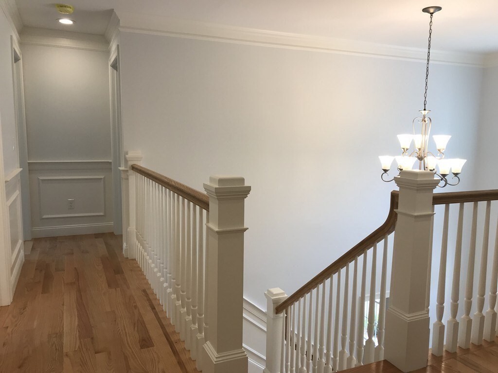 53 Wellesley Rd Extension Natick, MA 01760 - Photo 13 of 27 a view of a hallway with wooden floor and stairs