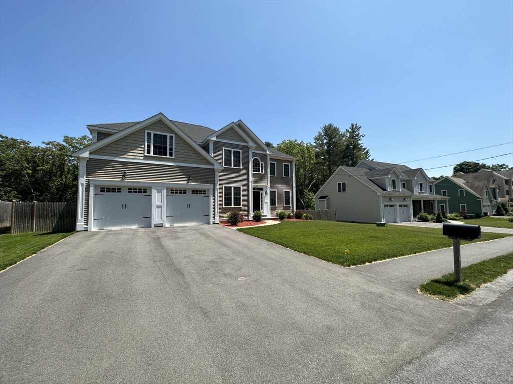53 Wellesley Rd Extension Natick, MA 01760 - Photo 2 of 27 a front view of a house with a yard and garage