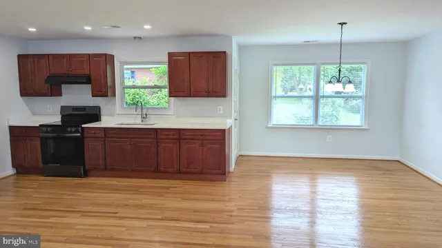 a kitchen with stainless steel appliances granite countertop a stove a sink and a wooden cabinets