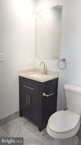a bathroom with a granite countertop toilet and a sink