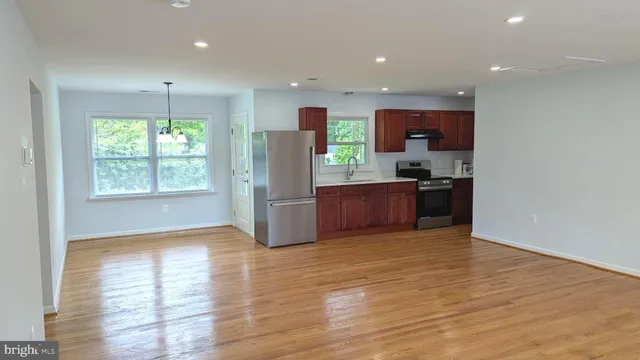 a view of kitchen with stainless steel appliances granite countertop cabinets and wooden floor
