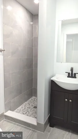 a bathroom with a sink shower and a mirror