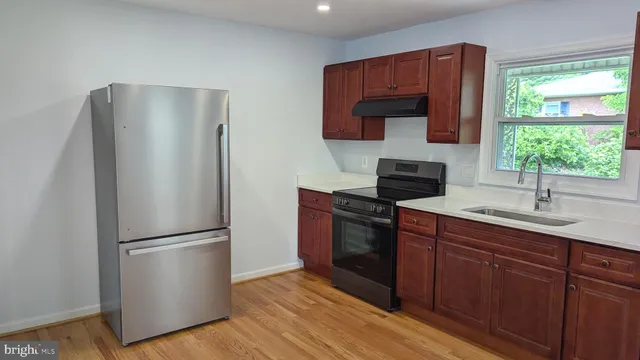 a kitchen with a refrigerator sink and cabinets