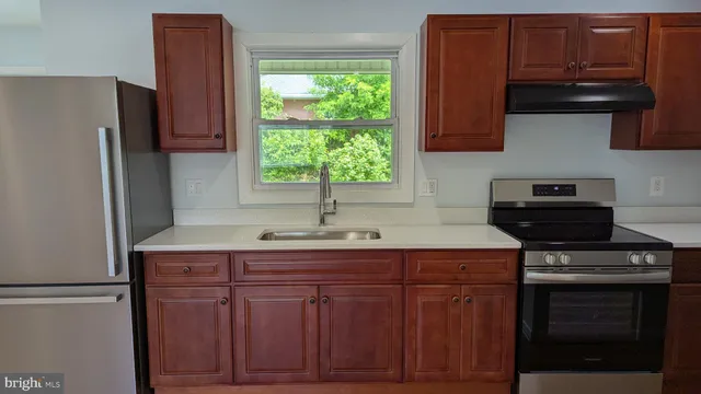 a view of kitchen with stainless steel appliances granite countertop cabinets and wooden floor