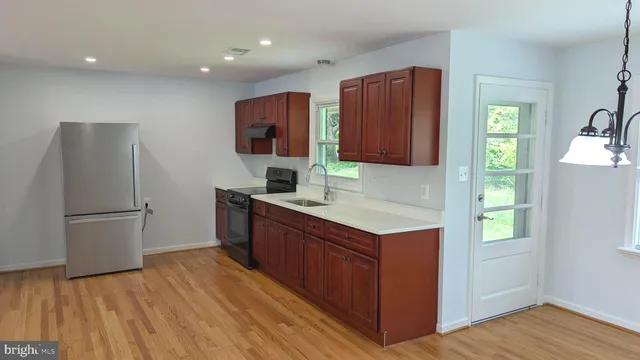 a kitchen with stainless steel appliances granite countertop a refrigerator and a stove top oven