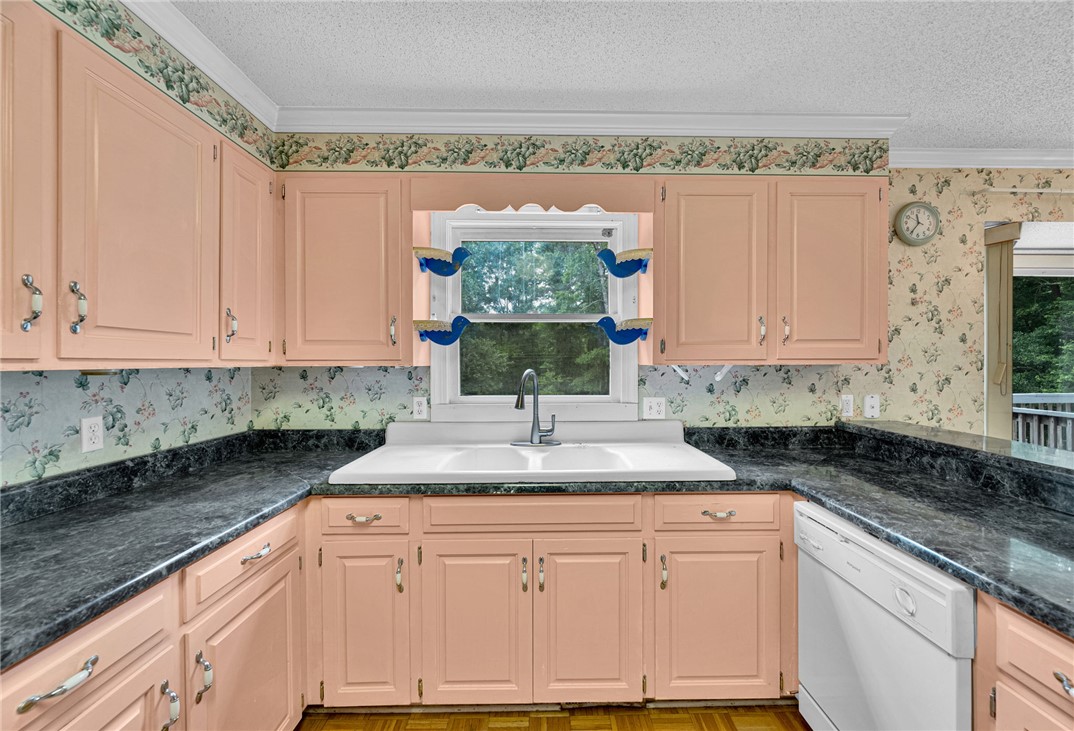 1016 Campbell Road Belton, SC 29627 - Photo 12 of 50 A well-lit kitchen featuring ample cabinetry, a double basin sink, and a view of verdant trees.