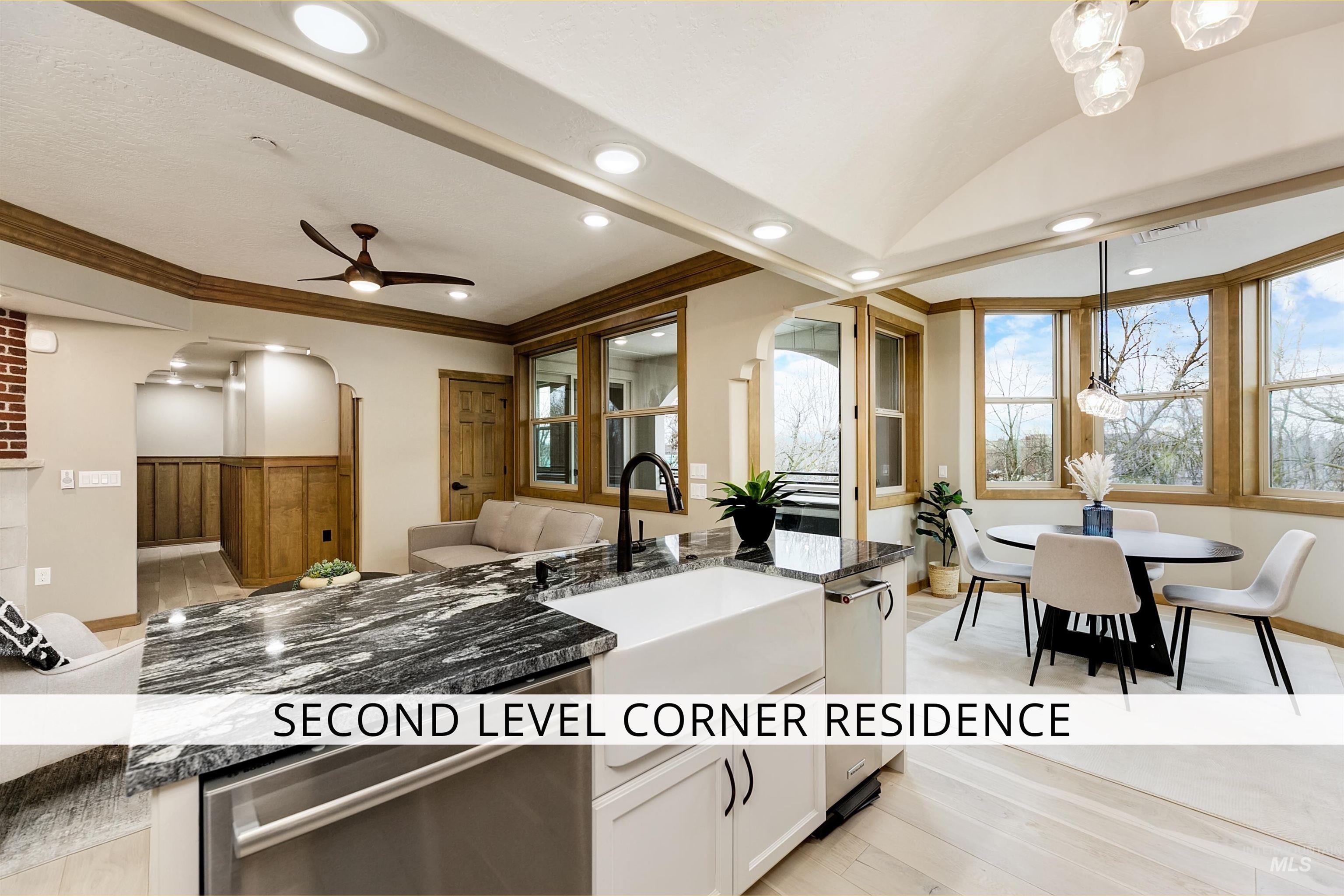 79 West Aikens Road, Unit 203 Eagle, ID 83616 - Photo 2 of 41 Kitchen featuring dark stone countertops, arched walkways, crown molding, light wood-style flooring, and a ceiling fan
