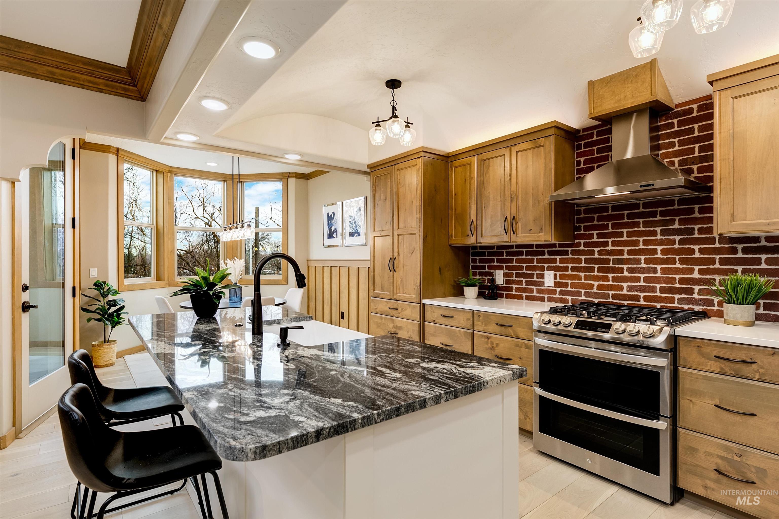 79 West Aikens Road, Unit 203 Eagle, ID 83616 - Photo 28 of 41 Kitchen with double oven range, a kitchen bar, dark stone countertops, a center island with sink, and two tone cabinets
