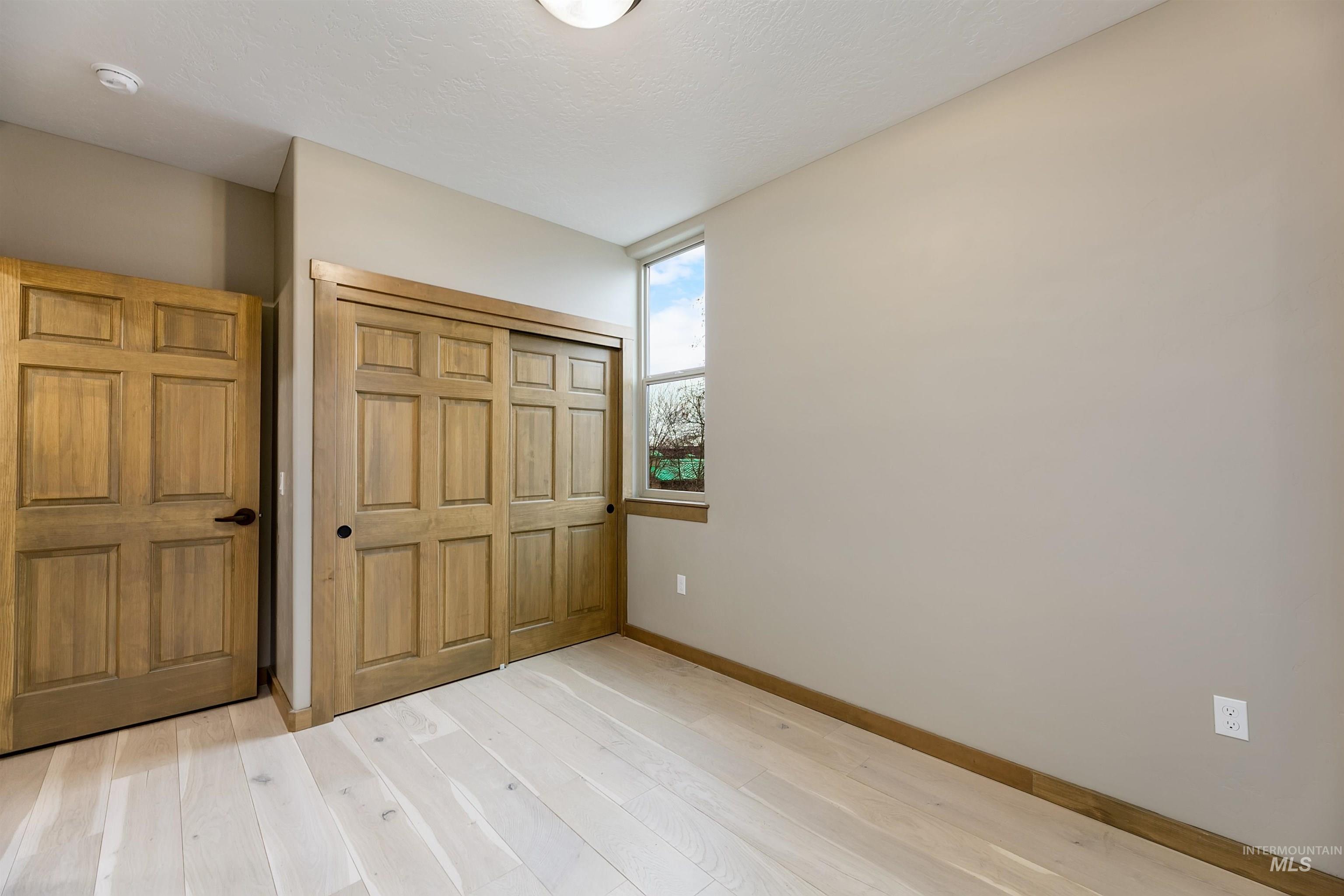 79 West Aikens Road, Unit 203 Eagle, ID 83616 - Photo 37 of 41 Unfurnished bedroom with light wood-style floors and a closet