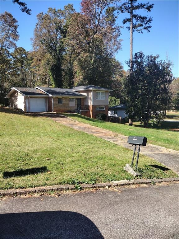 a front view of a house with a yard and lake view