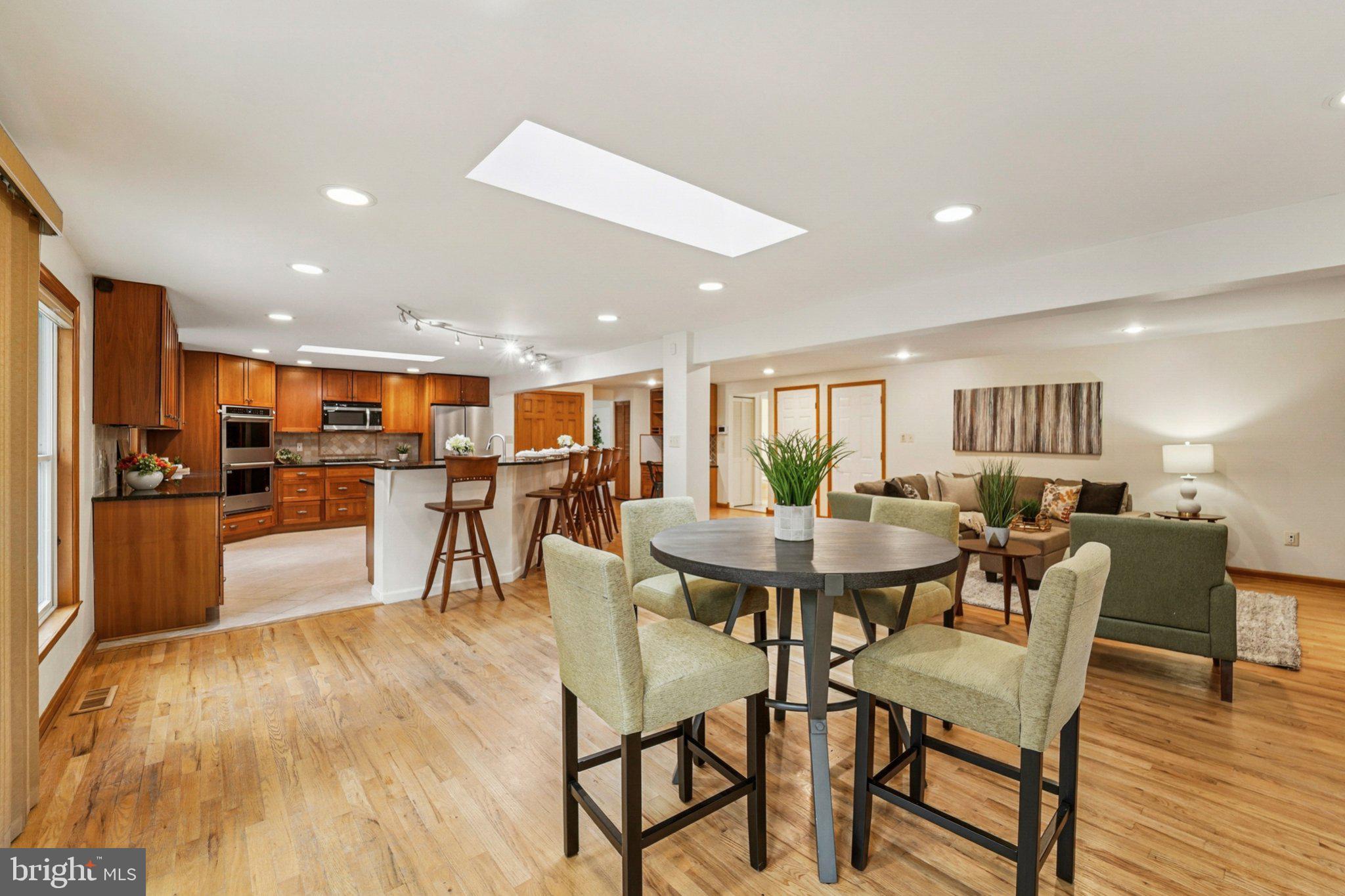 a dining room with stainless steel appliances kitchen island a table and chairs