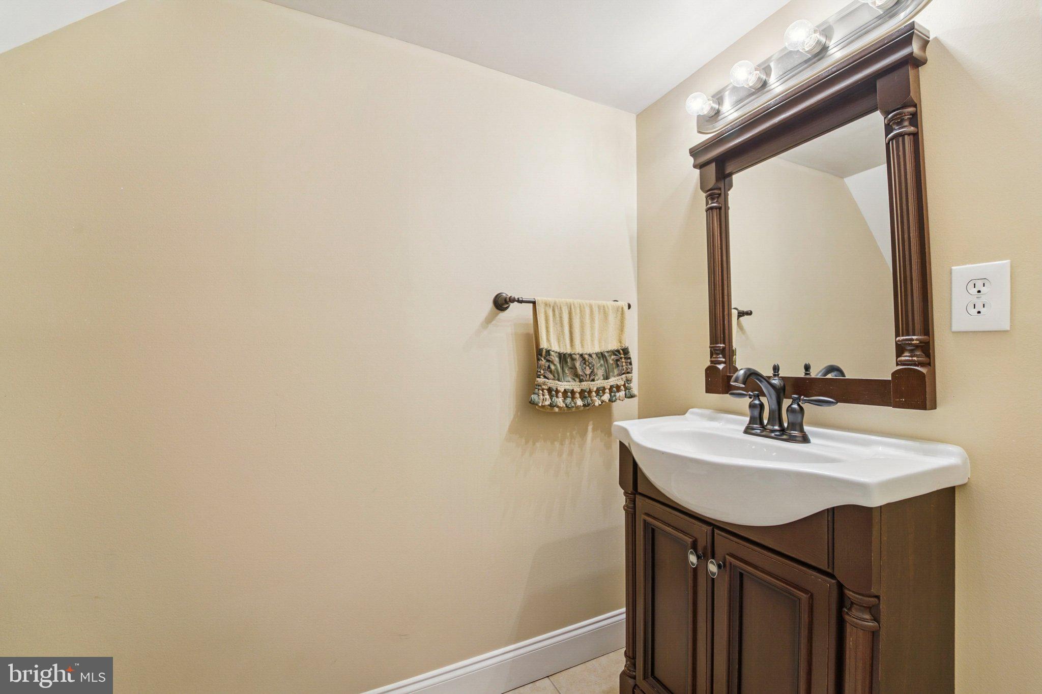 14820 Windmill Terrace Silver Spring, MD 20905 - Photo 26 of 33 a bathroom with a sink a mirror and a vanity