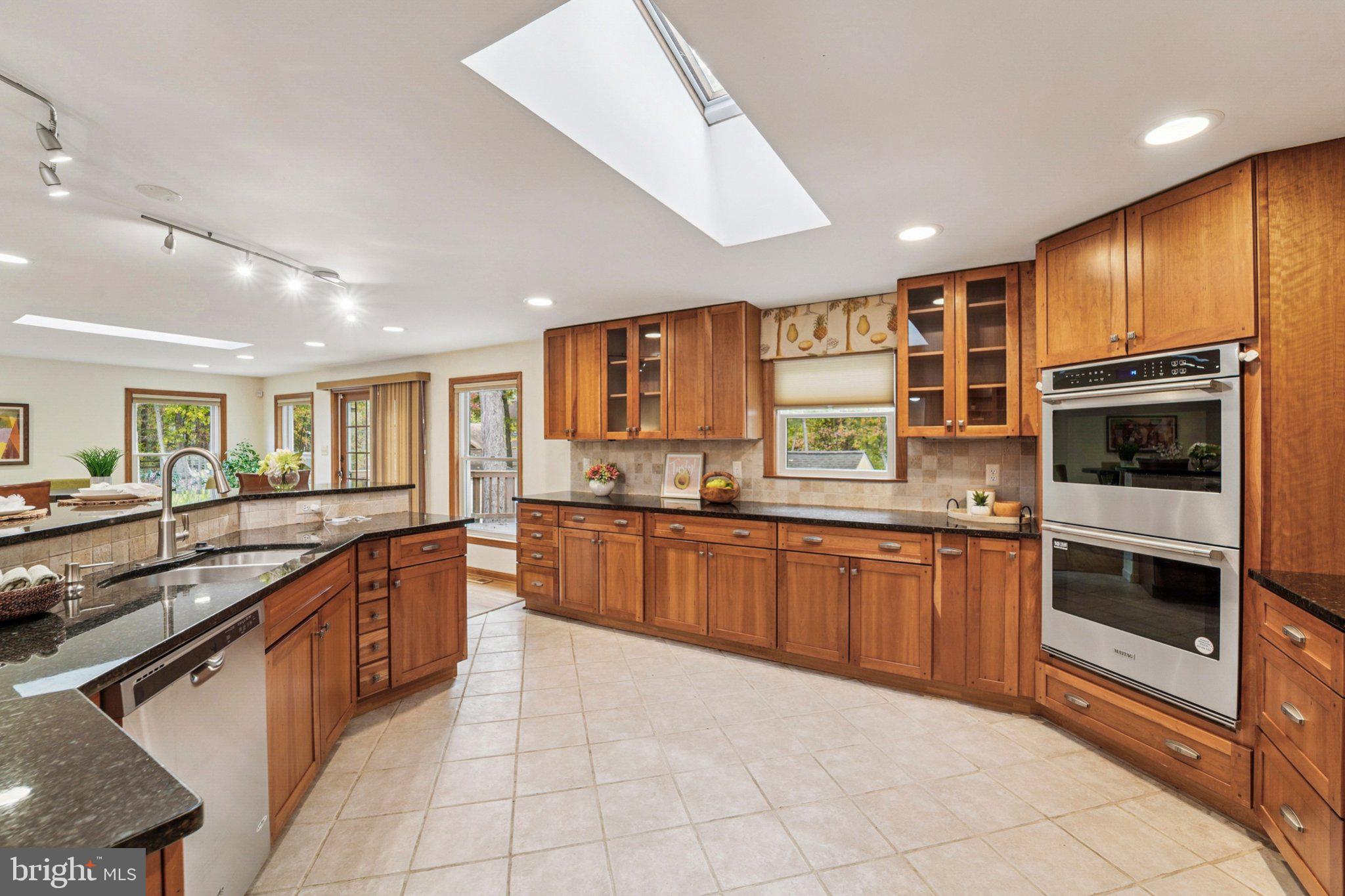14820 Windmill Terrace Silver Spring, MD 20905 - Photo 7 of 33 a kitchen with stainless steel appliances granite countertop wooden cabinets a sink dishwasher a stove and a refrigerator