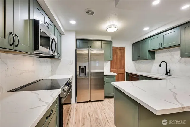 a kitchen with stainless steel appliances a sink microwave and stove