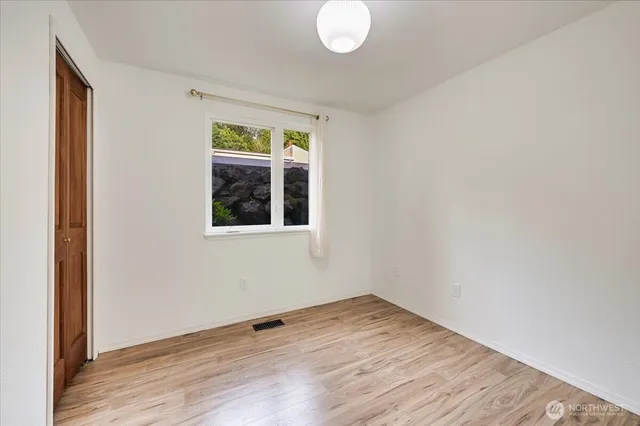 a view of a room with wooden floor and window