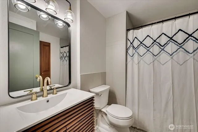 a bathroom with a sink a toilet and a mirror