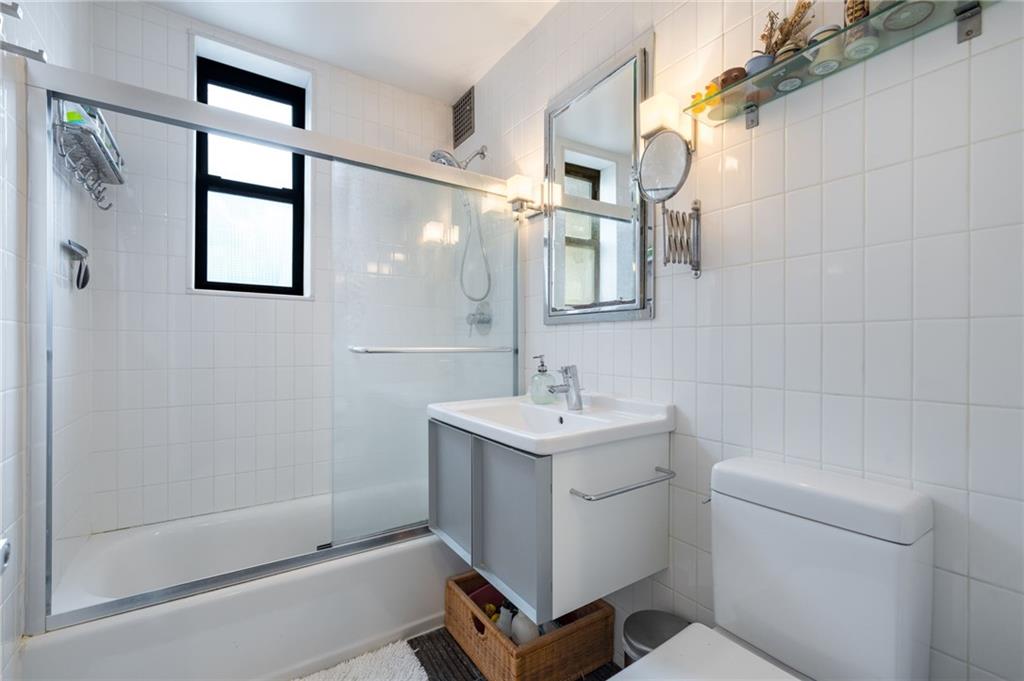 515 East 7th Street, Unit 5H Brooklyn, NY 11218 - Photo 13 of 17 a bathroom with a sink a toilet and shower