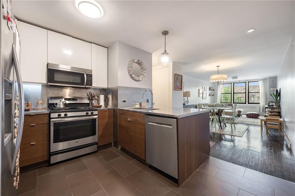 515 East 7th Street, Unit 5H Brooklyn, NY 11218 - Photo 7 of 17 a kitchen with stainless steel appliances kitchen island granite countertop a stove and a sink