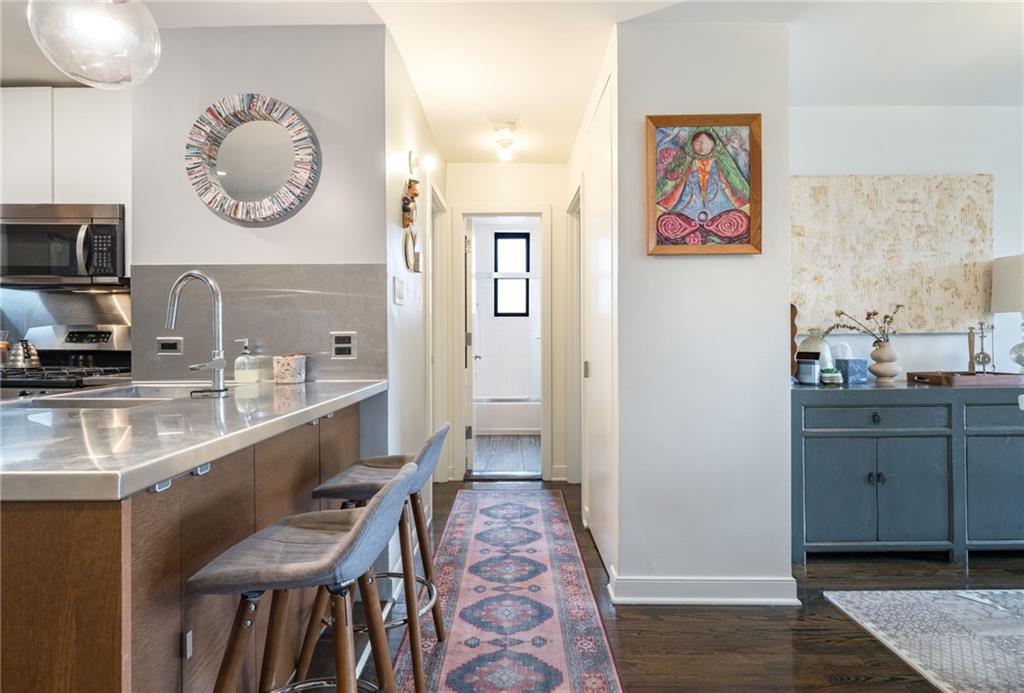 515 East 7th Street, Unit 5H Brooklyn, NY 11218 - Photo 8 of 17 a very nice looking open kitchen with stainless steel appliances granite countertop a sink and a wooden floor