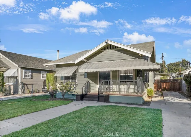 a front view of a house with a garden and trees
