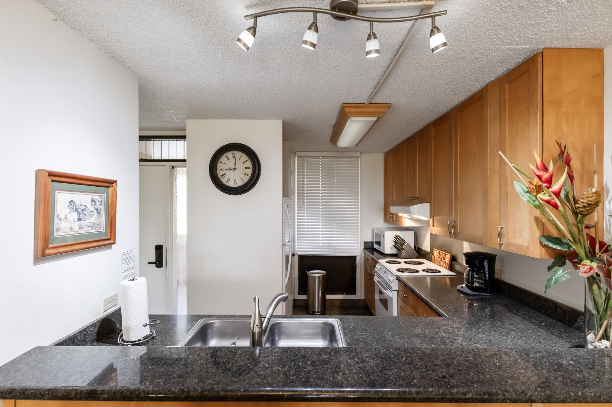 2695 South Kihei Road, Unit 4301 Kihei, HI 96753 - Photo 4 of 45 a kitchen with stainless steel appliances granite countertop a sink dishwasher a stove top oven a dining table and chairs with wooden floor