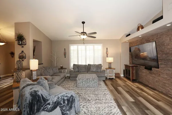 a living room with furniture a ceiling fan and a rug