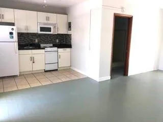 a kitchen with stainless steel appliances a stove a sink and white cabinets