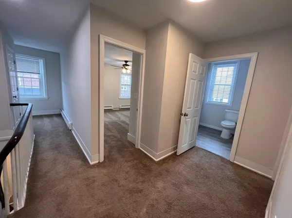 an empty room with windows and fan
