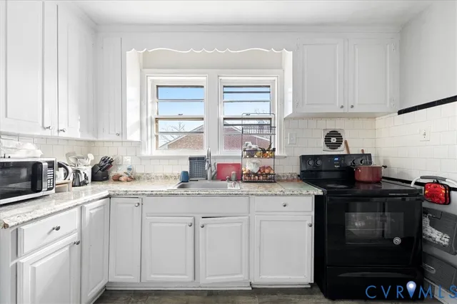 a kitchen with granite countertop a sink cabinets and window