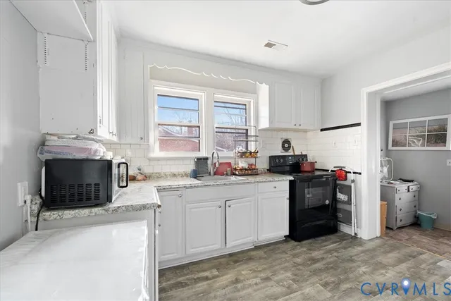 a kitchen with a sink stove top oven and cabinets