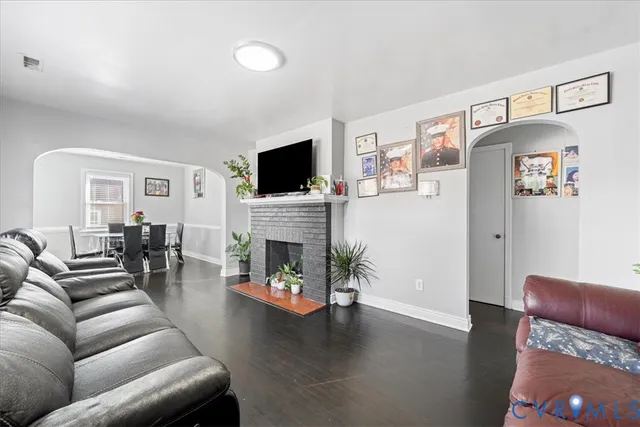 a living room with furniture a fireplace and a flat screen tv