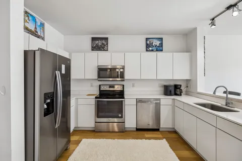 a kitchen with stainless steel appliances granite countertop a refrigerator sink and stove