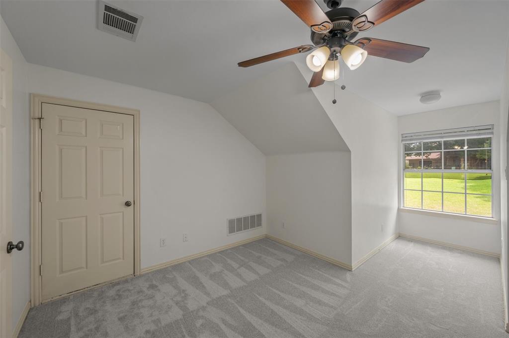 5607 Ranger Drive Rockwall, TX 75032 - Photo 28 of 40 Room featuring light gray patterned carpeting, a multi-pane window, a ceiling fan with light fixture, and a neutral-toned six-panel door