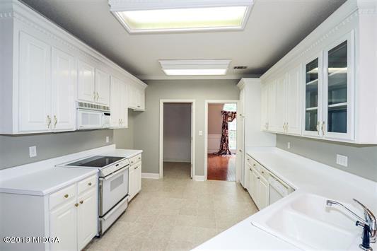 105 Wilton Circle Perry, GA 31069 - Photo 11 of 35 a kitchen with granite countertop a sink and cabinets