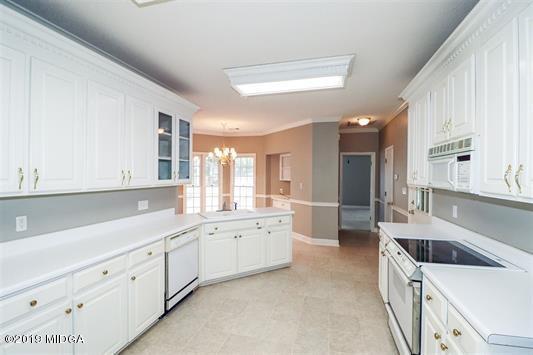 105 Wilton Circle Perry, GA 31069 - Photo 12 of 35 a kitchen with granite countertop white cabinets and white appliances