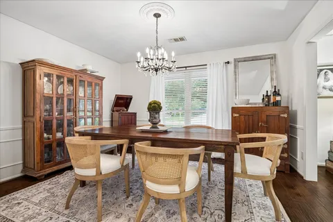 a view of a dining room with furniture a chandelier and wooden floor