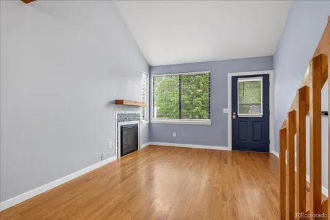 a view of an empty room with window and fire place