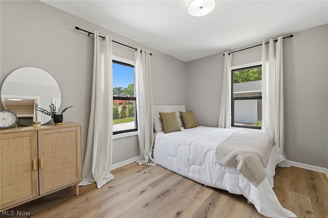 951 Bey Road Akron, OH 44312 - Photo 17 of 34 First floor bright bedroom featuring two large windows with black frames, wood-finish flooring, and light gray wall paint