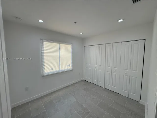 a bathroom with a granite countertop sink mirror vanity and toilet