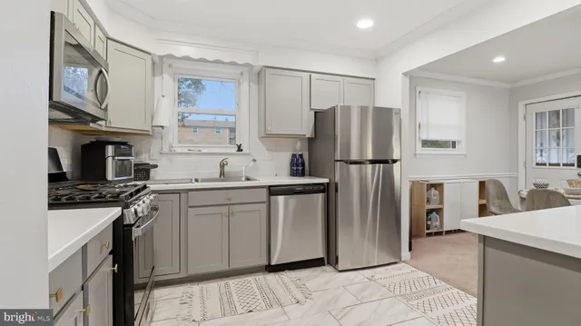 a kitchen with stainless steel appliances granite countertop a refrigerator sink and stove