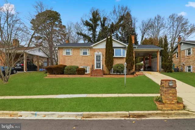 a front view of a house with a garden and trees